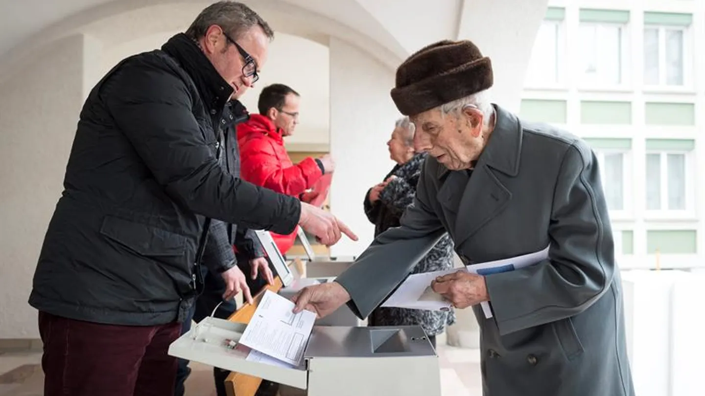 Un hombre deposita su voto en una oficina electoral en Appenzell, Suiza. Un hombre deposita su voto en una oficina electoral en Appenzell, Suiza.