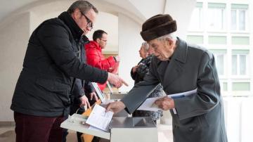 Un hombre deposita su voto en una oficina electoral en Appenzell, Suiza.