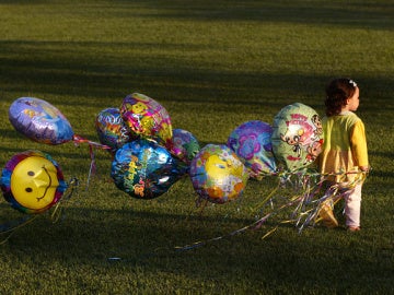 Una niña con globos de helio Una niña con globos de helio