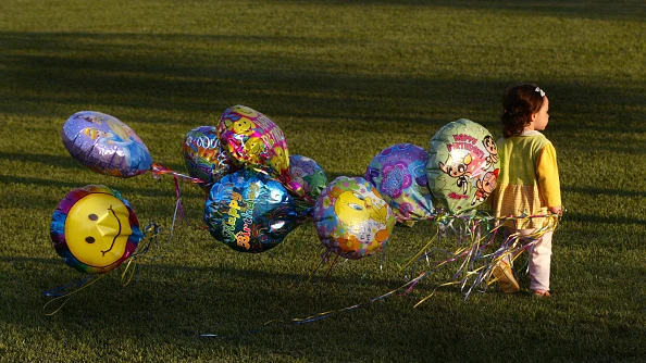 Una niña con globos de helio Una niña con globos de helio