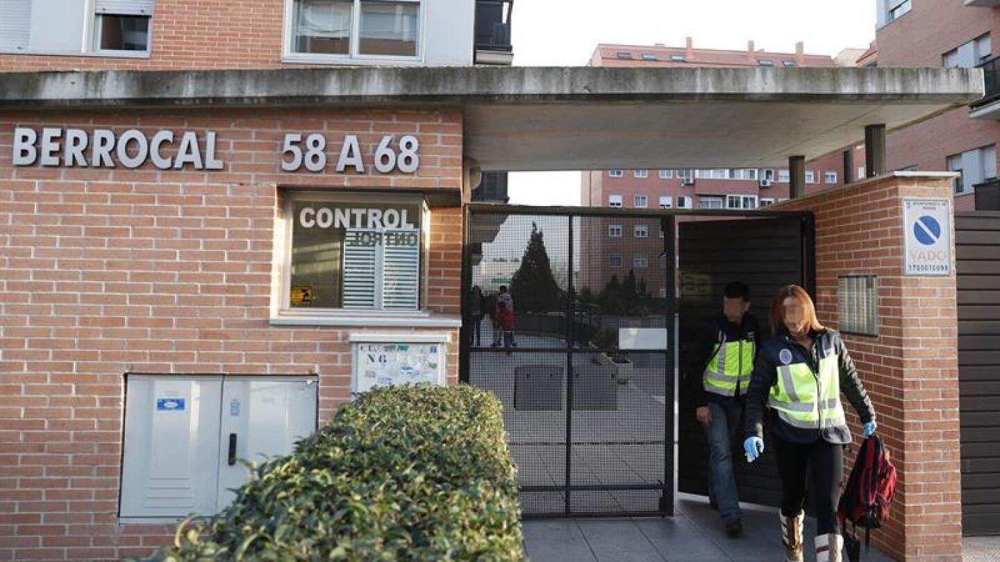 Agentes de la Polic&iacute;a cient&iacute;fica salen del bloque de viviendas donde se ha producido un tiroteo