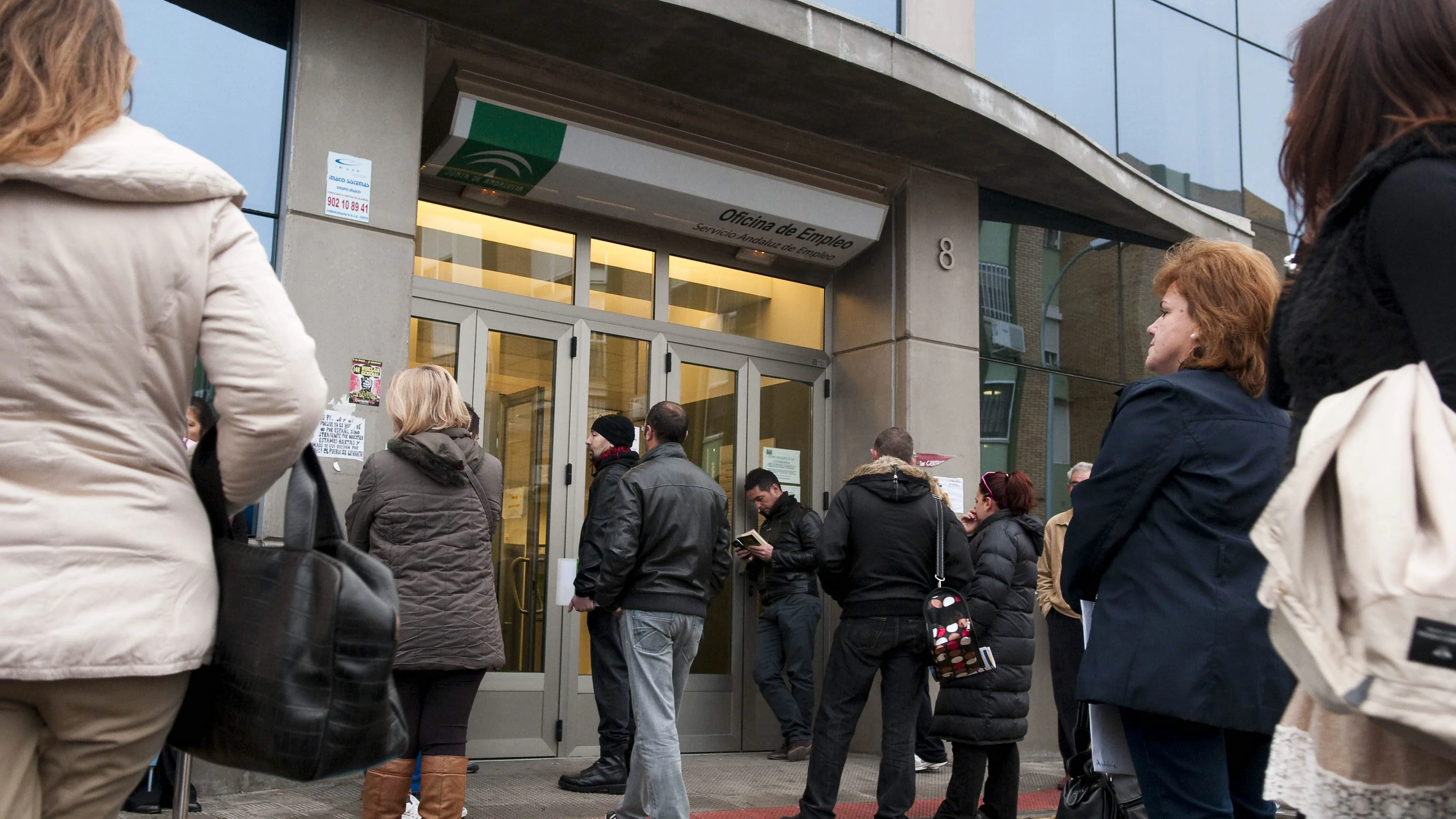 Numerosas personas esperan a las puertas de una oficina de empleo Numerosas personas esperan a las puertas de una oficina de empleo