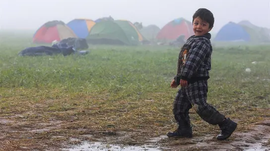 Un niño camina por el campo de refugiados cerca de Idomeni Un niño camina por el campo de refugiados cerca de Idomeni