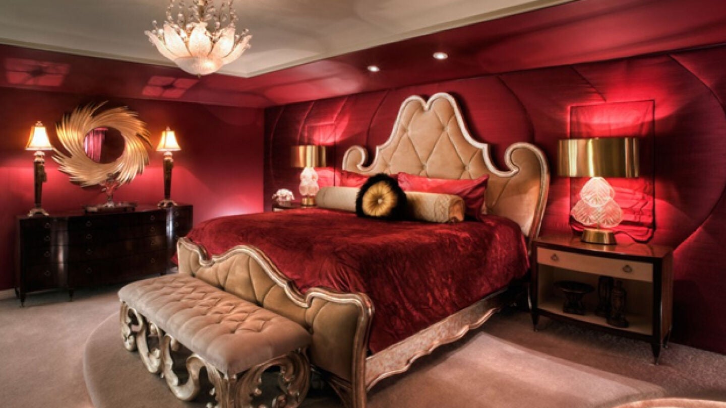 Imagen de una cama con una colcha roja