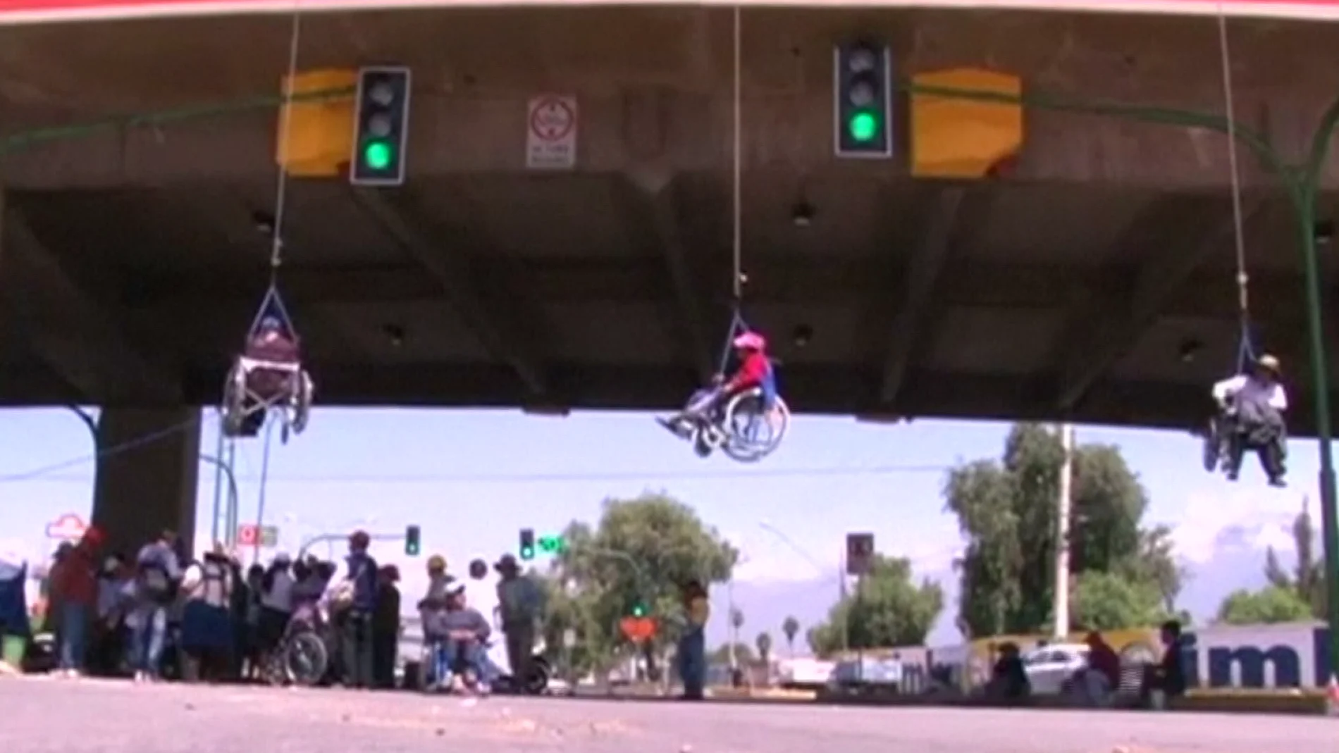 Personas con discapacidad se cuelgan de un puente