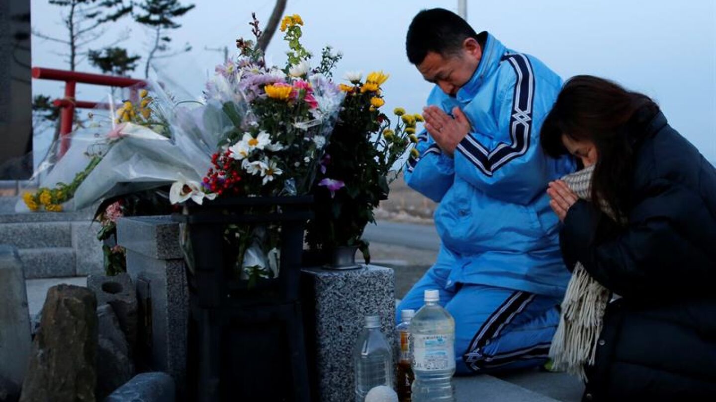  Una pareja reza ante un altar en memoria de las v&iacute;ctimas del terremoto y posterior tsunami 