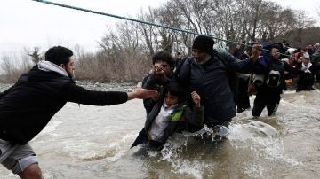 Refugiados atravesando un río revuelto