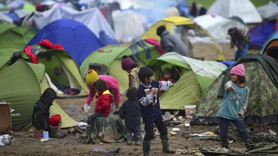 Varios niños juegan cerca de las tiendas de campaña Varios niños juegan cerca de las tiendas de campaña