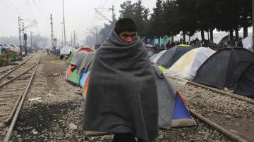 Un joven refugiado cubre su cuerpo con un manta en el campamento provisional de Idomeni, en la frontera entre Grecia y Macedonia (Grecia). 