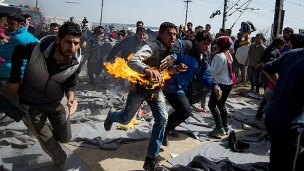 Imagen del refugiado corriendo mientras se quema Imagen del refugiado corriendo mientras se quema