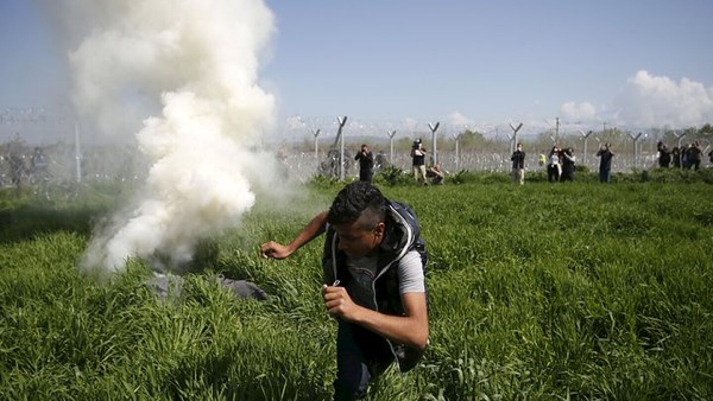 Imagen de refugiados en Idomeni junto al gas lacrim&oacute;geno
