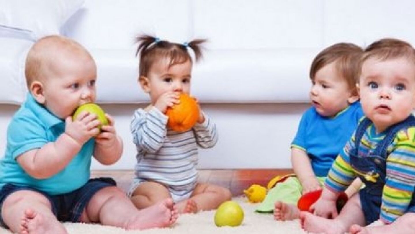 Varios beb&eacute;s comiendo fruta