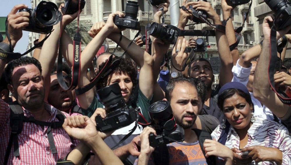 Periodistas alzan sus cámaras en señal de protesta durante una manifestación en El Cairo