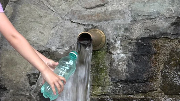 Imagen de una persona llenando una botella de agua