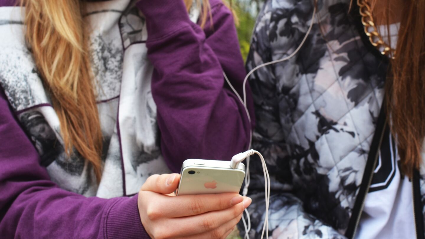 Unas j&oacute;venes con un tel&eacute;fono m&oacute;vil