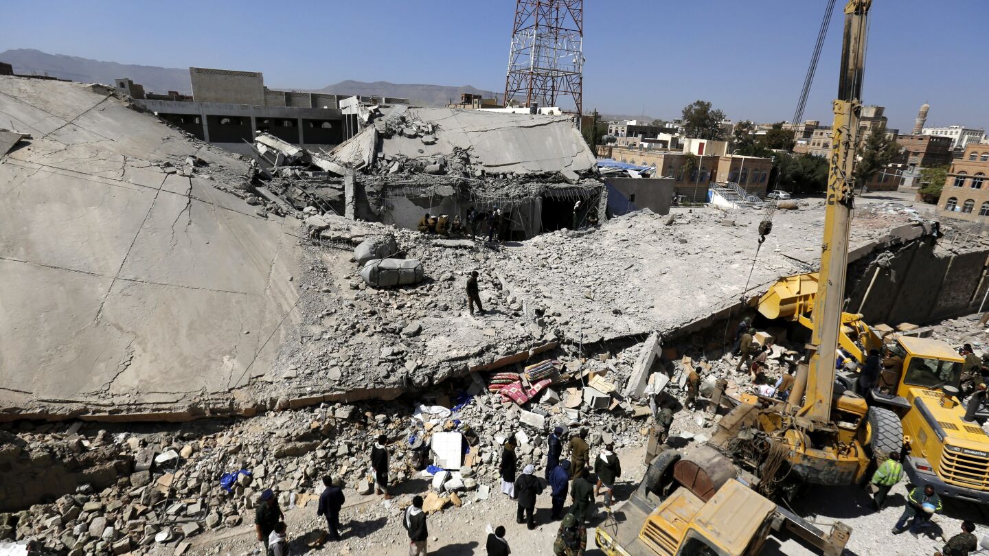 Un grupo de personas inspeccion los restos de la sede principal de la Polic&iacute;a tras un bombardeo en Yemen