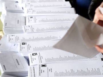 Una persona introduce una papeleta electoral en un sobre. Una persona introduce una papeleta electoral en un sobre.