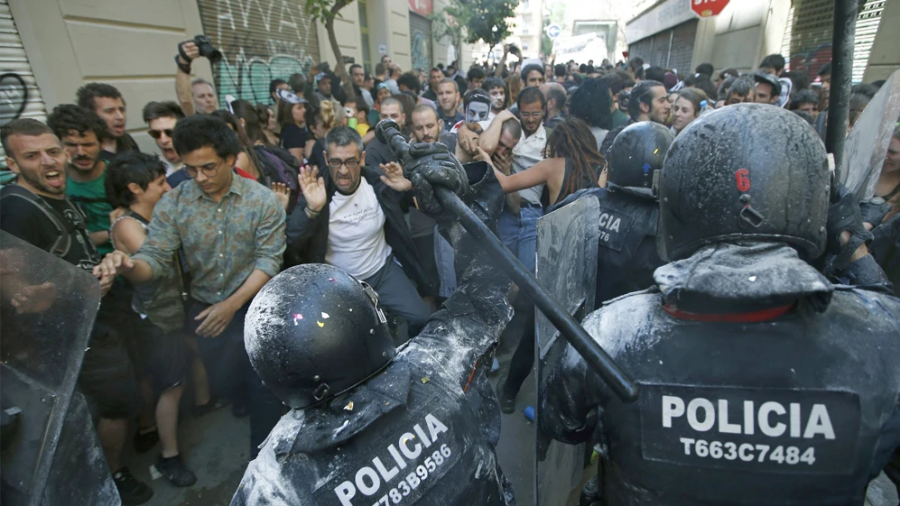 Manifestantes y antidisturbios de los Mossos d'Esquadra, durante los incidentes producidos en el barrio de Gràcia