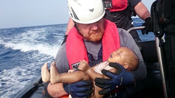 Martin sujeta a un bebé fallecido durante una travesía en el Mediterráneo