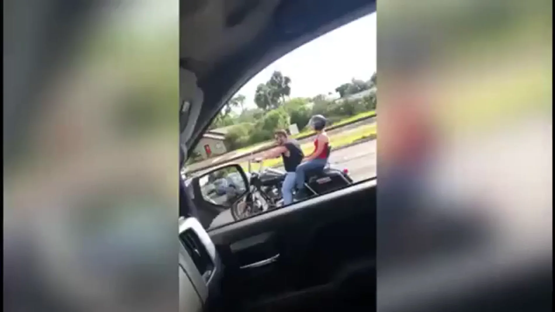 Frame 0.0 de: Un conductor atropella a un motorista con su coche durante una discusión de tráfico