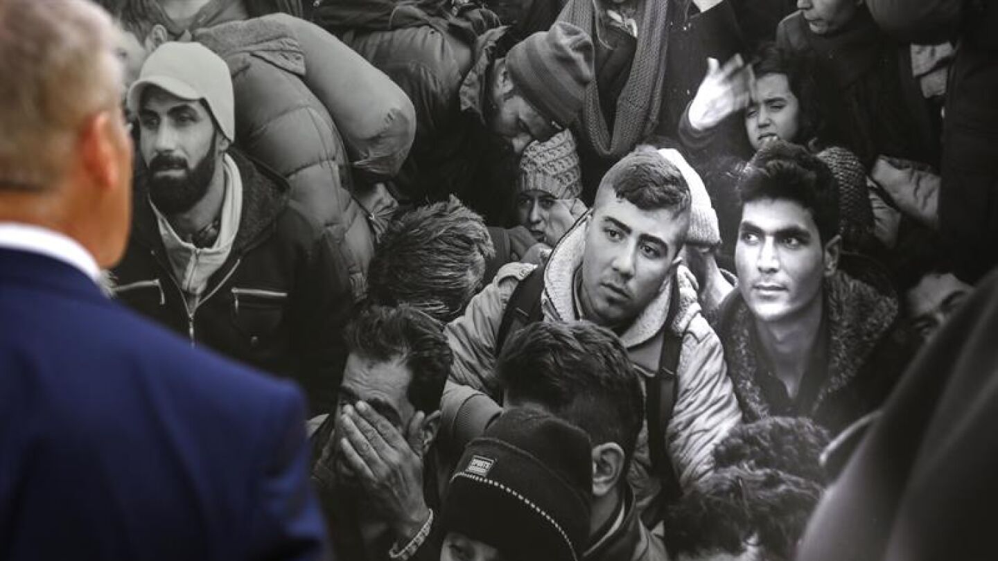 Un hombre observa una imagen que forma parte de la exposici&oacute;n fotogr&aacute;fica 'Caminos del exilio'