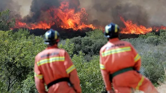 Dos bomberos observan las llamas cerca de la localidad de Sumacarcer (Valencia) Dos bomberos observan las llamas cerca de la localidad de Sumacarcer (Valencia)