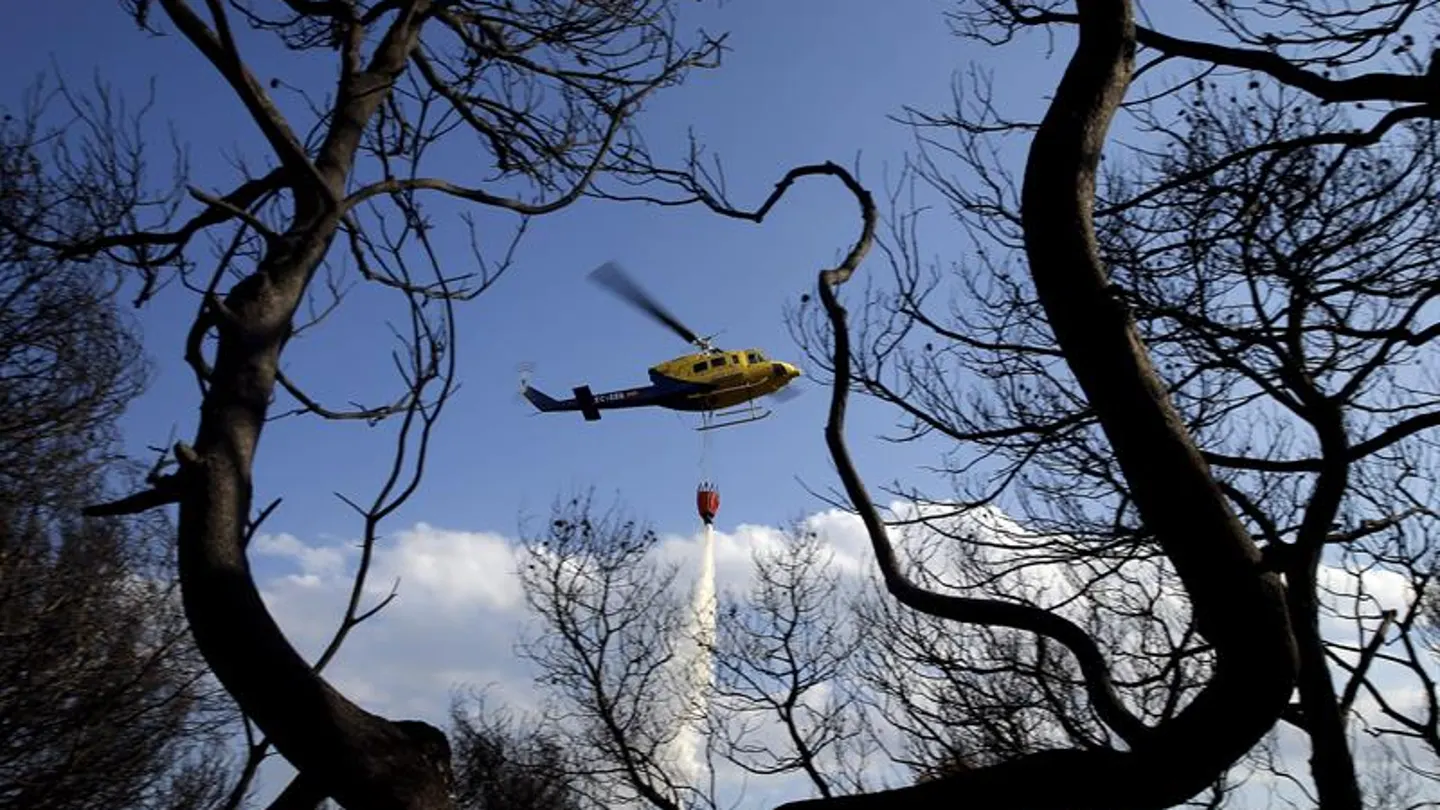 Un helicóptero intenta sofocar un incendio Un helicóptero intenta sofocar un incendio