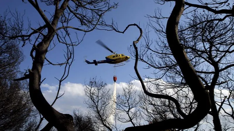 Un helicóptero intenta sofocar un incendio Un helicóptero intenta sofocar un incendio