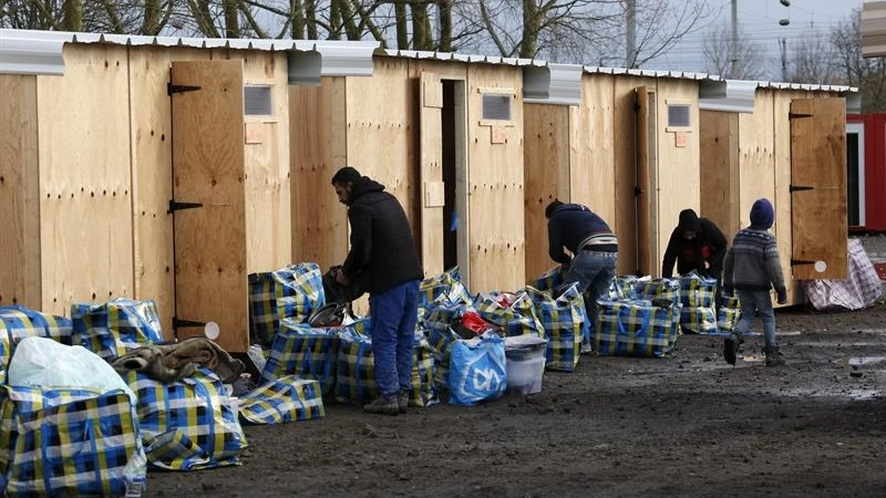 Varios refugiados se trasladan a sus cabañas en un campamento habilitado por la organización Médicos sin Fronteras