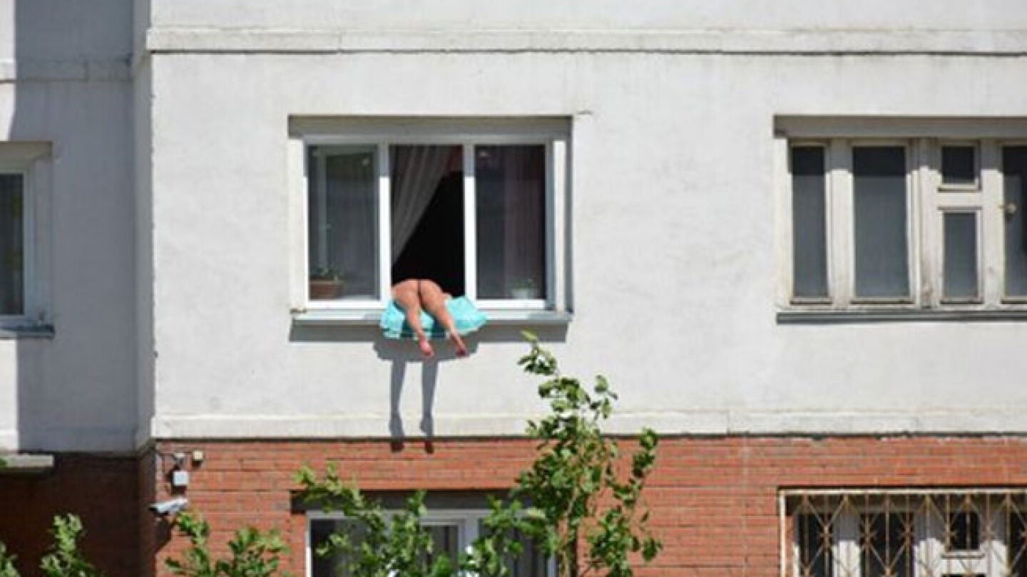 La mujer tomando el sol en su ventana