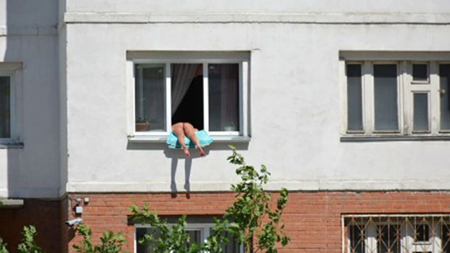 La mujer tomando el sol en su ventana La mujer tomando el sol en su ventana
