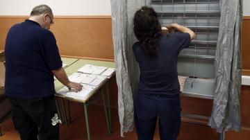 Operarios del Ayuntamiento de Pamplona colocan en un colegio electoral de la capital navarra