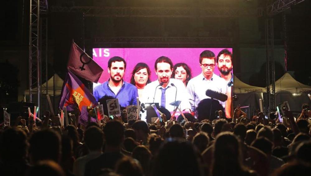 Simpatizantes de Unidos Podemos escuchan las declaraciones de su líder Pablo Iglesias