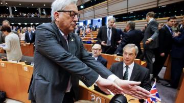 Juncker, intenta tapar la cámara a un fotógrafo que enfoca a Farage