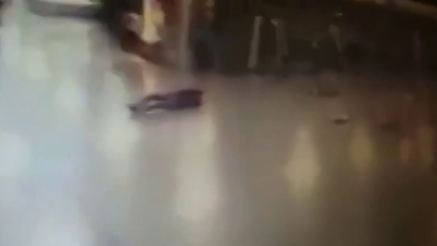 Frame 13.076645 de: Un polic&iacute;a dispara contra uno de los terroristas del aeropuerto de Estambul y huye justo antes de que este se inmole