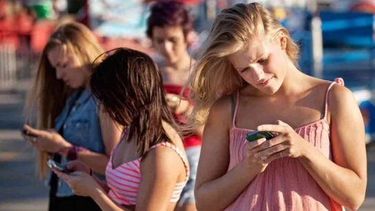 Un grupo de chicas consulta su teléfono móvil Un grupo de chicas consulta su teléfono móvil