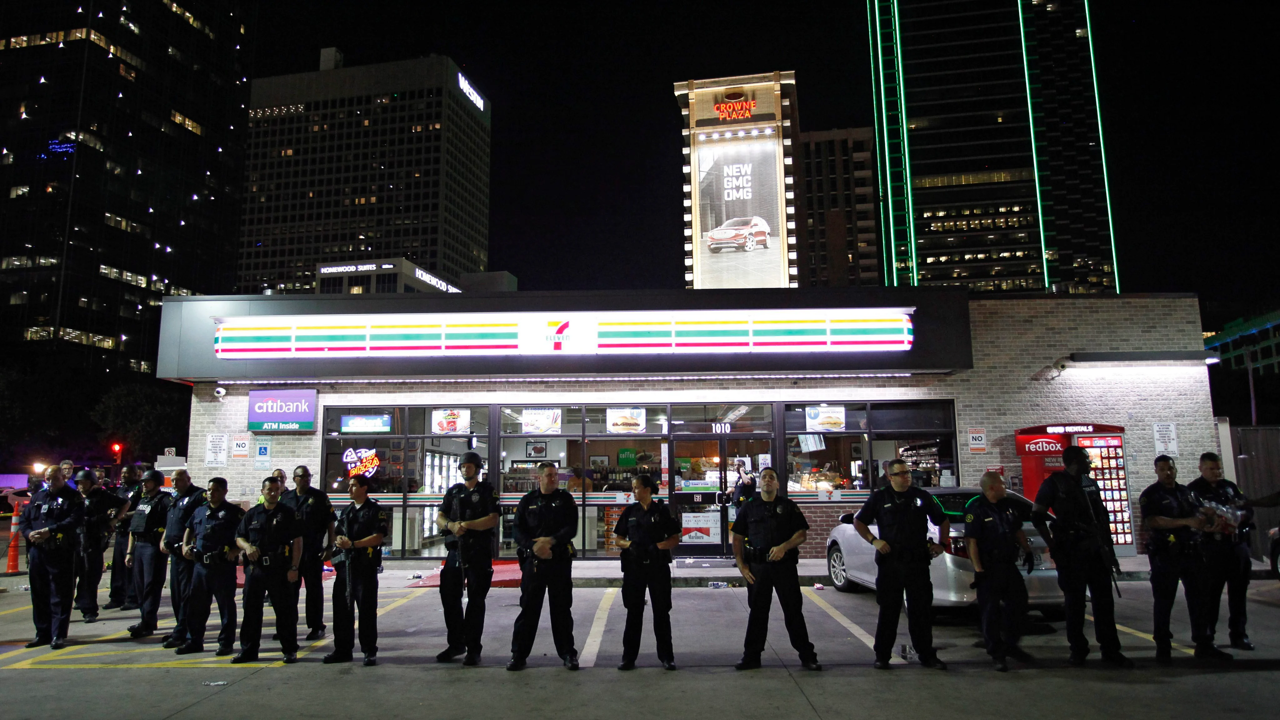 Agentes de la policía de Dallas permanecen en guardia en la esquina de Ross Avenue con Griffin Street durante una manifestación contra la violencia policial hacia los negros en EEUU 