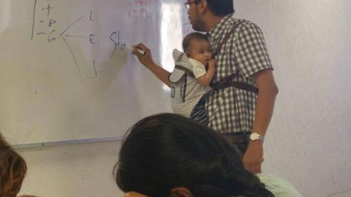 Profesor con el beb&eacute; cogido