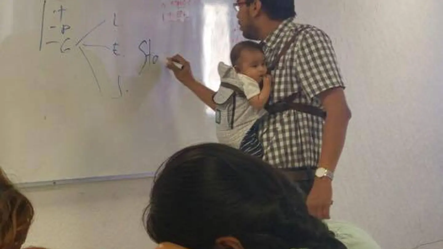 Profesor con el bebé cogido Profesor con el bebé cogido