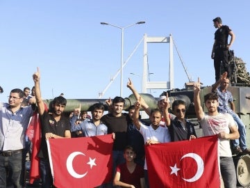 Partidarios del presidente Recep Tayyip Erdogan muestran la bandera nacional junto a un tanque. Partidarios del presidente Recep Tayyip Erdogan muestran la bandera nacional junto a un tanque.