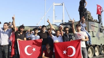 Partidarios del presidente Recep Tayyip Erdogan muestran la bandera nacional junto a un tanque.