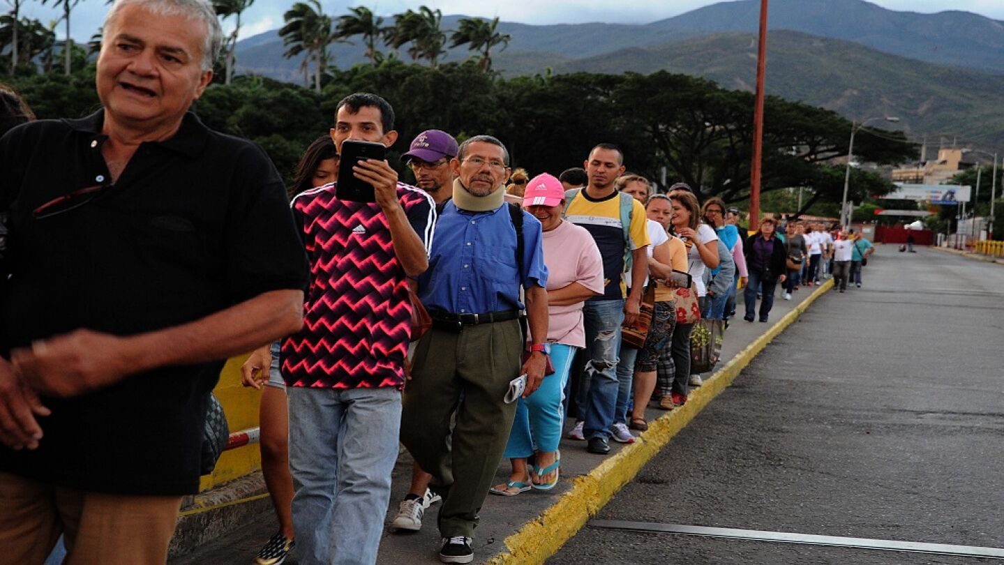 Un grupo de personas forma una fila en el puente fronterizo "Sim&oacute;n Bol&iacute;var" entre Colombia y Venezuela.