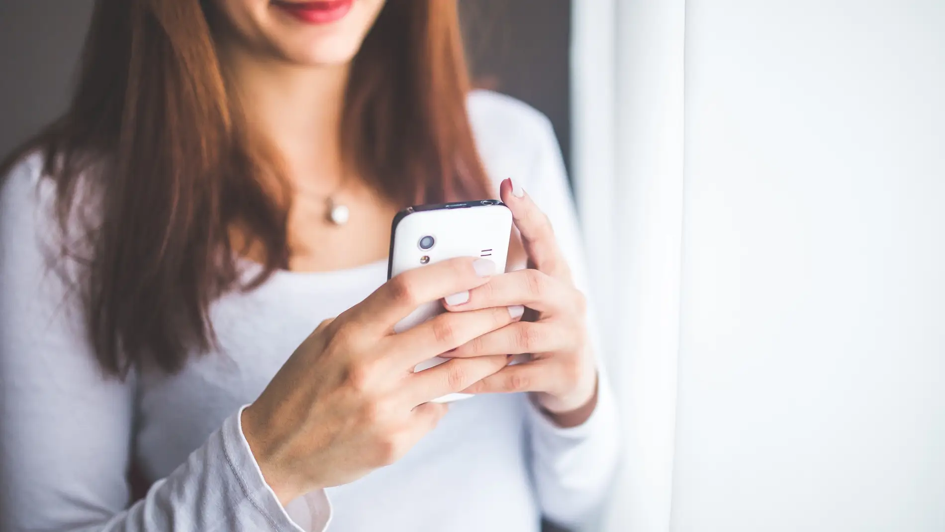 Mujer escribe en su teléfono móvil