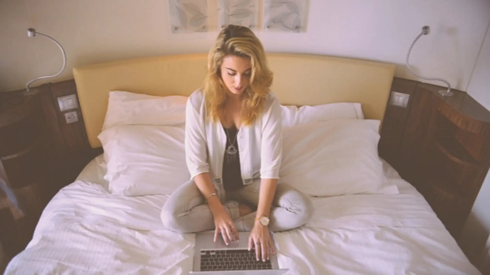 Una chica en la cama con un portátil