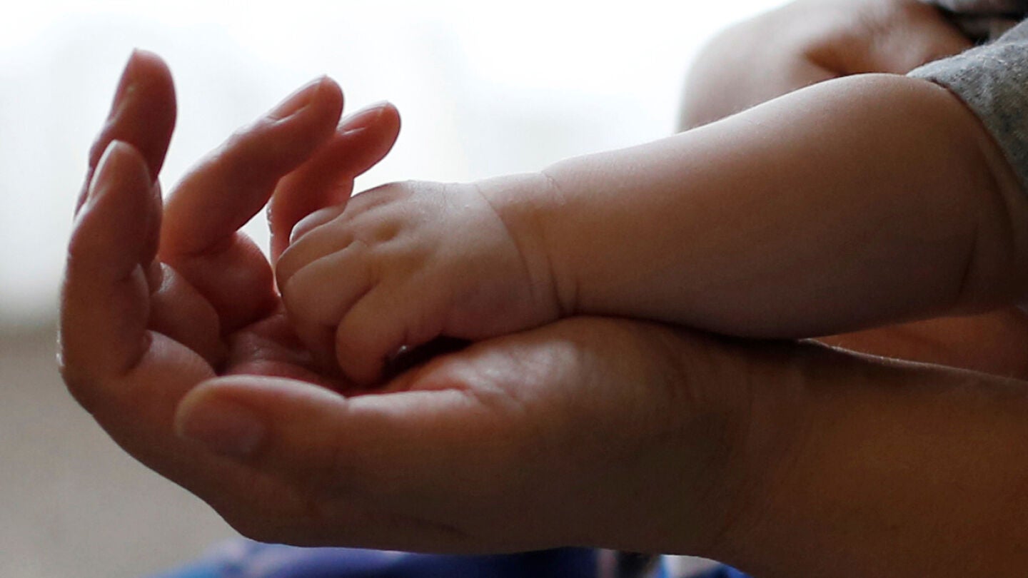La mano de un beb&eacute; sobre la de un adulto