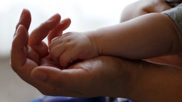 La mano de un bebé sobre la de un adulto