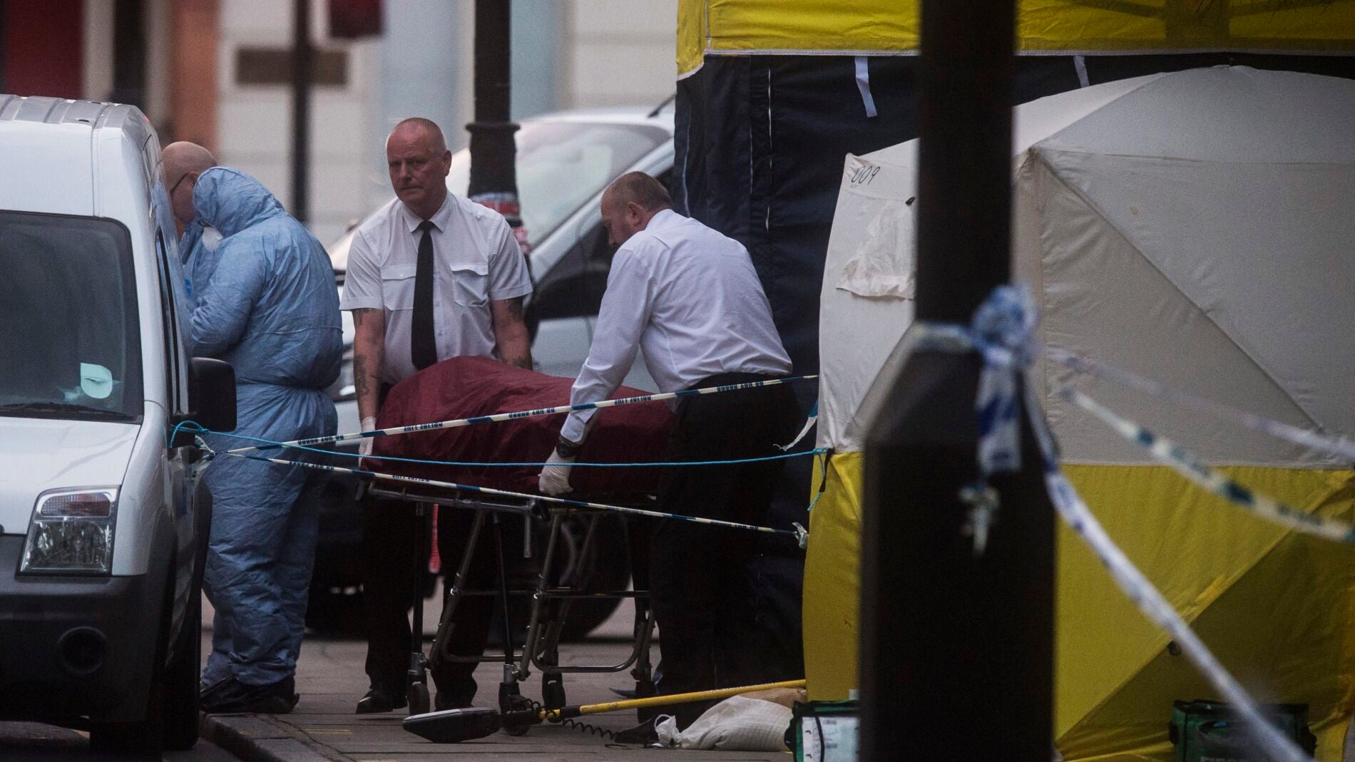 Investigadores retiran un cuerpo en la escena donde una mujer murió en Londres