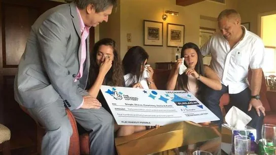 La familia emocionada delante del boleto premiado La familia emocionada delante del boleto premiado