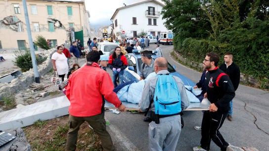 Los equipos de rescate llevan a una persona en una camilla tras el terremoto en Amatrice