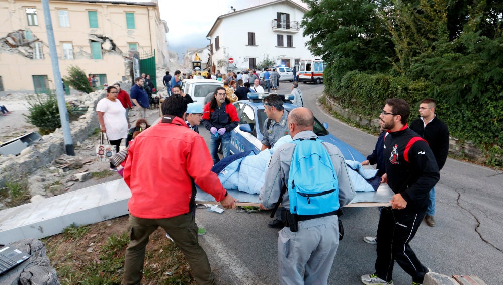 Los equipos de rescate llevan a una persona en una camilla tras el terremoto en Amatrice